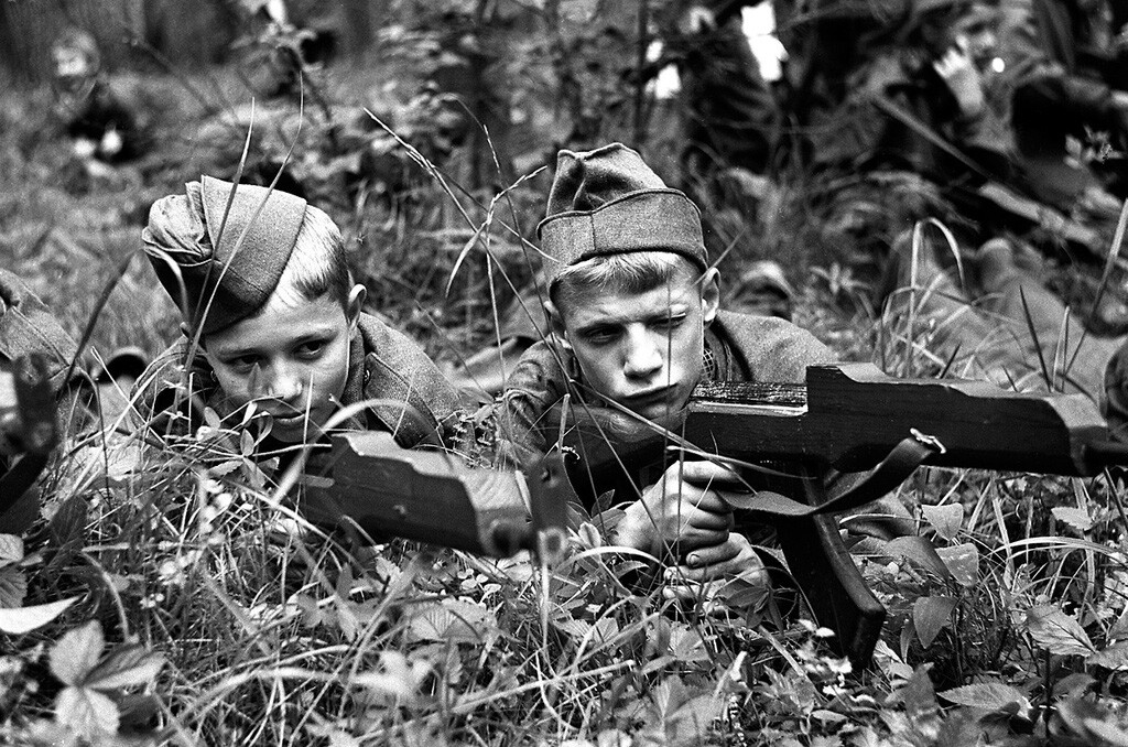 Kinder und Pioniere aus dem ganzen Land bei spielerischen Militärmanövern mit Spielzeugwaffen. 