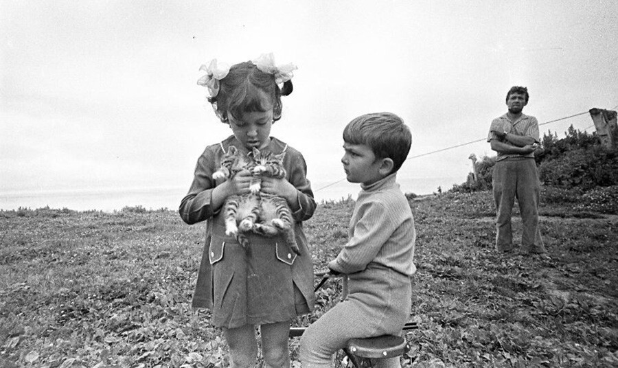 Kinder spielen mit jungen Kätzchen auf der Insel Moneron, Sachalin. 