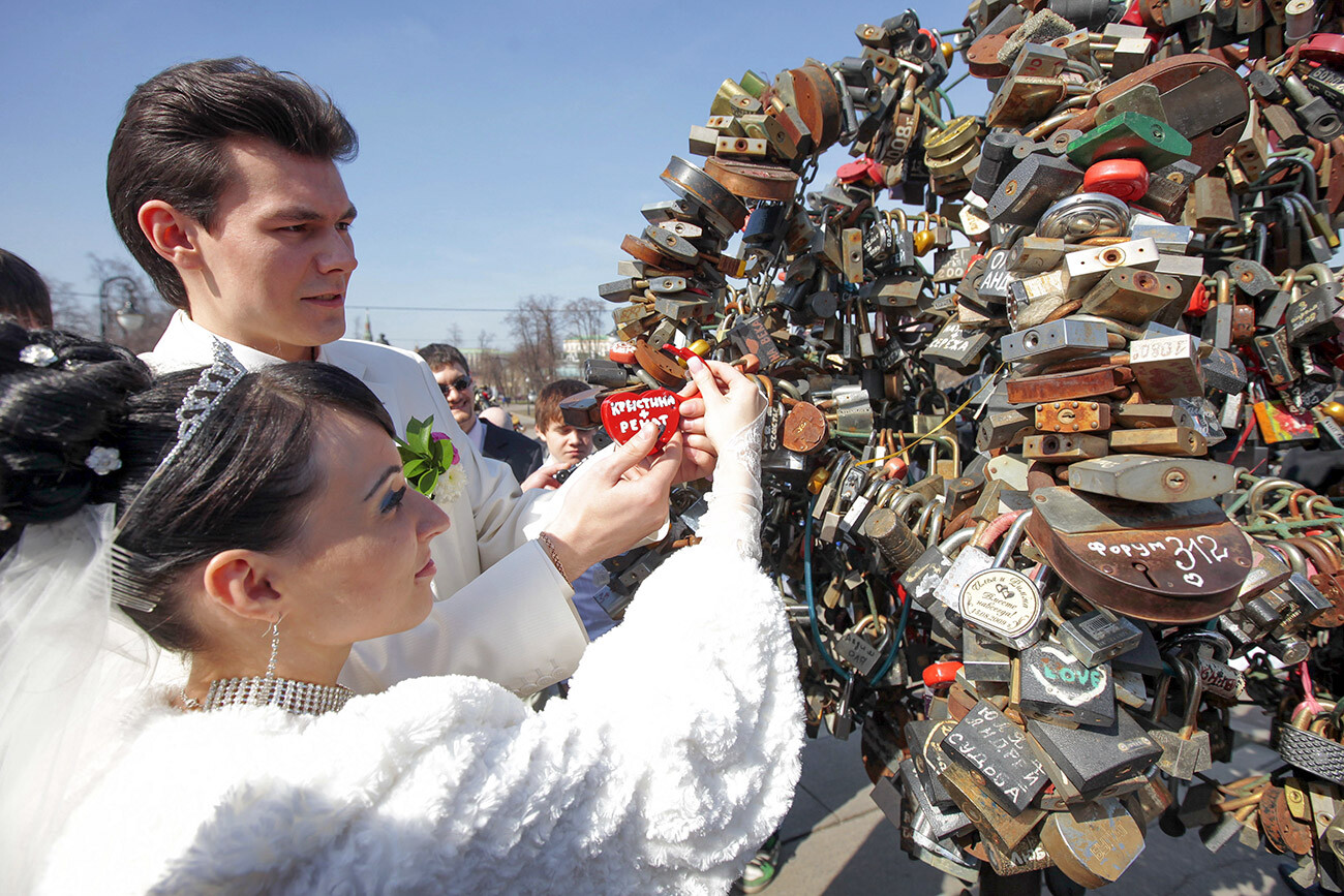 Jeunes mariés sur le pont Loujkovy de Moscou accrochant un cadenas symbolisant leur union lors de Krasnaïa Gorka