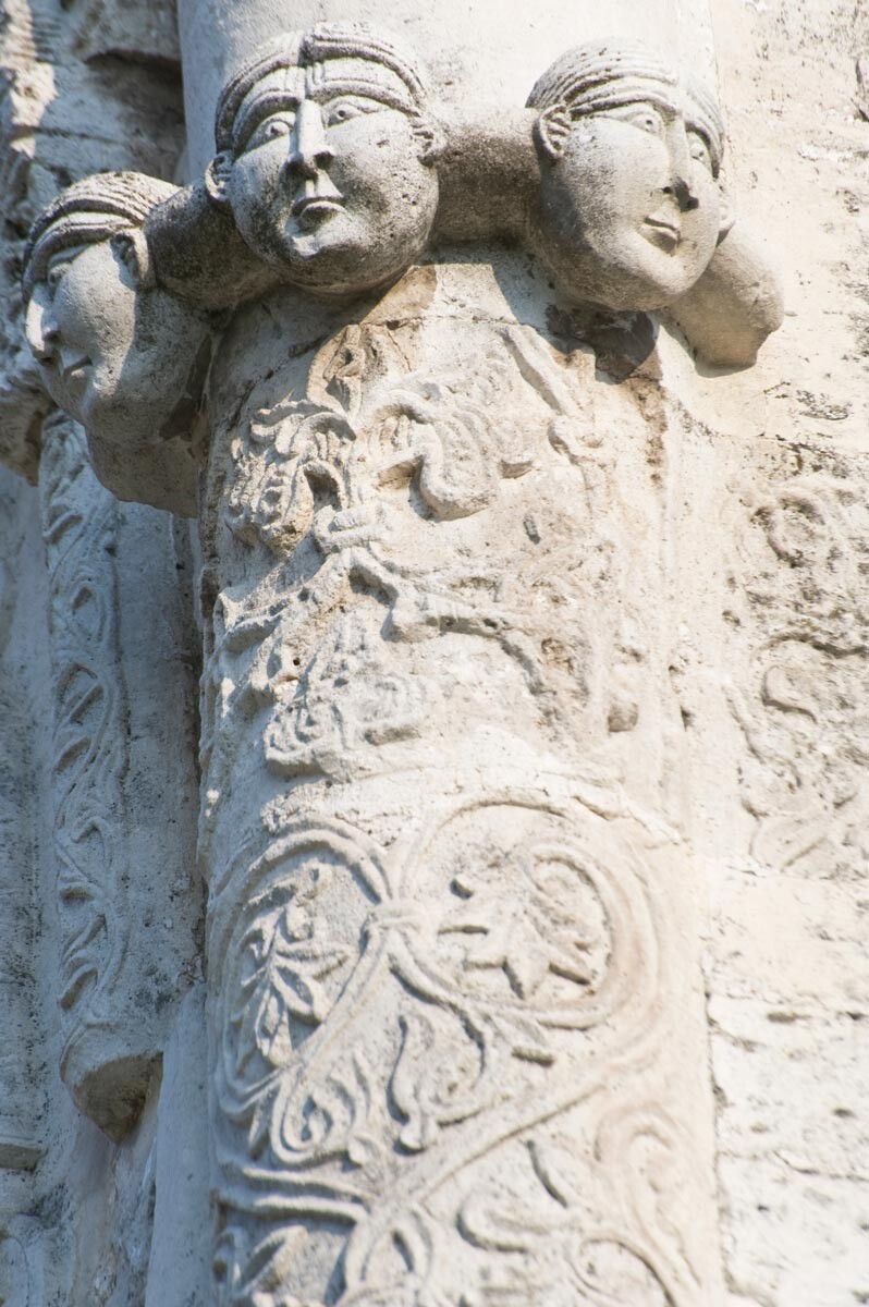 Cathedral of St. George, northwest corner. Attached column with carved heads. August 21, 2013