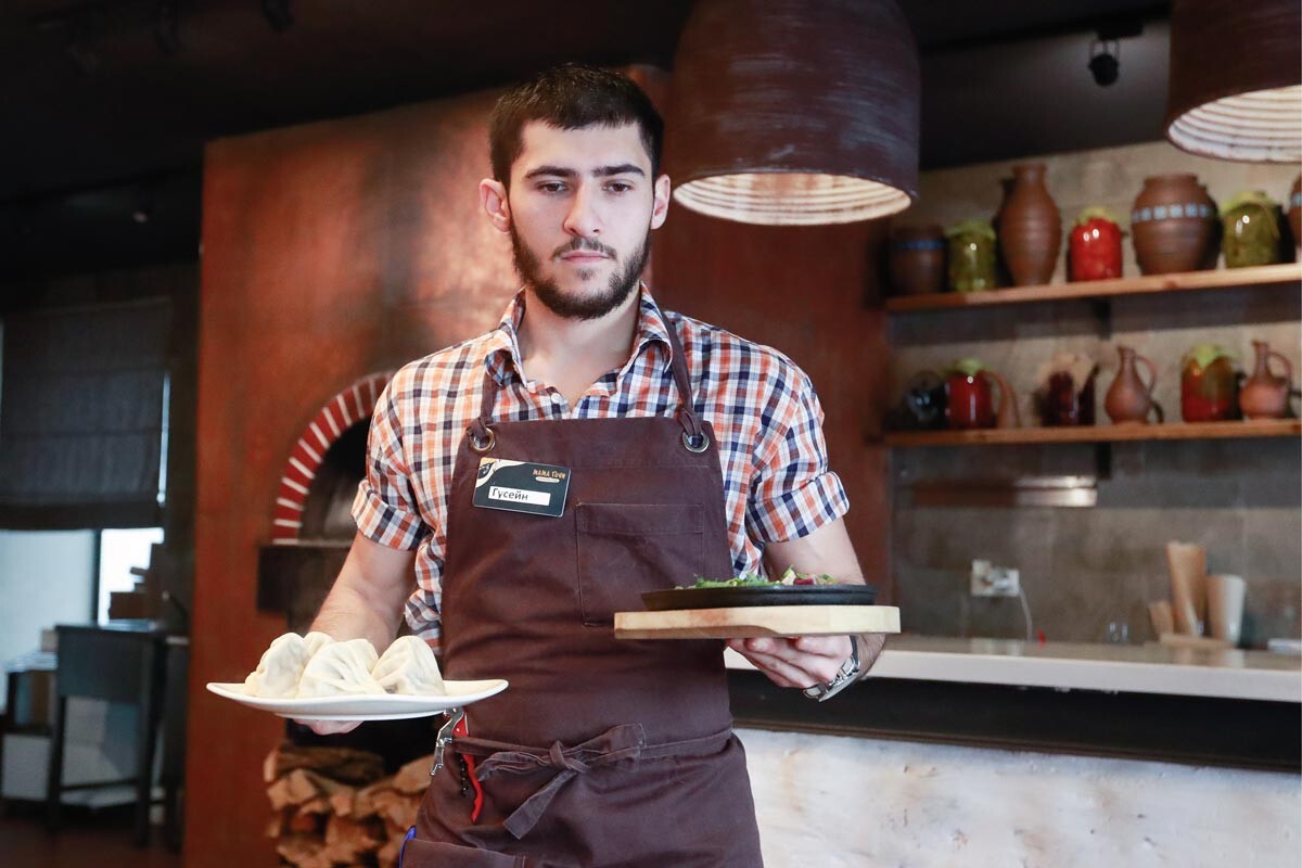 Employé d'un restaurant géorgien servant des khinkali