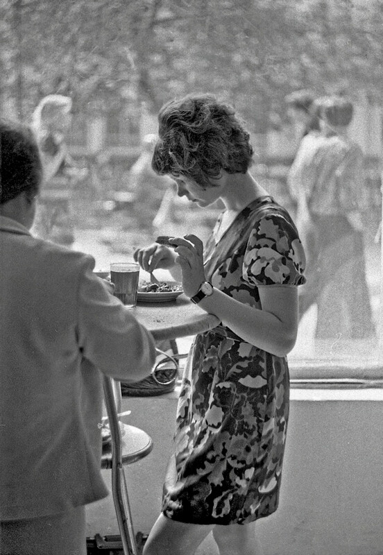 Une jeune femme déjeune dans un café, 1975