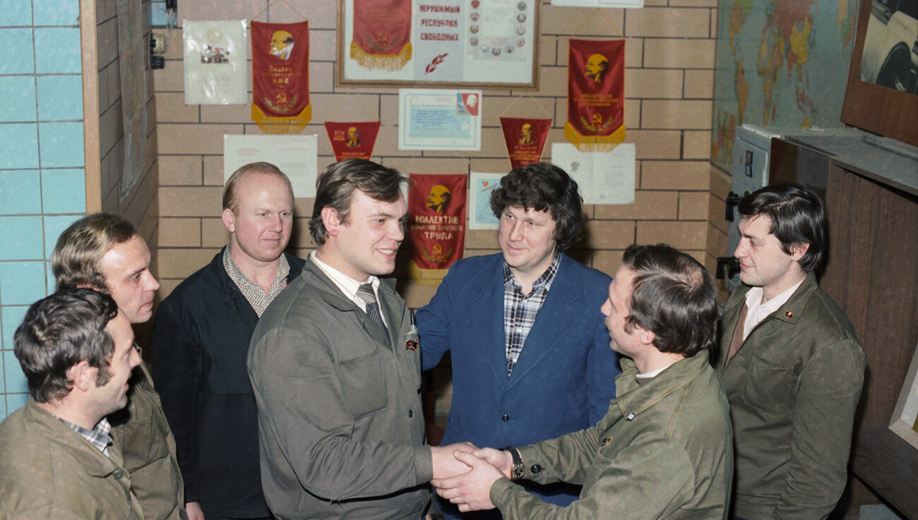 Orang-orang mengucapkan selamat kepada rekan mereka yang diterima sebagai anggota Partai Komunis Uni Soviet.