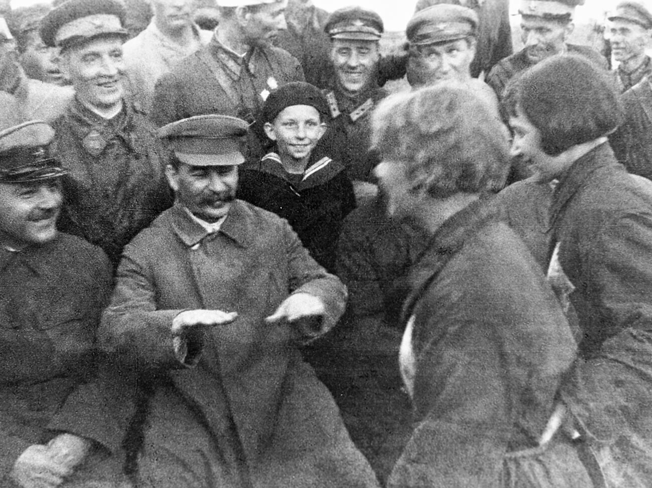 Generalni sekretar Centralnega komiteja Vsesovjetske komunistične partije boljševikov Josif Stalin (drugi z leve) in Kliment Vorošilov (levo) se pogovarjata s piloti in padalci na letališču Tušino. 