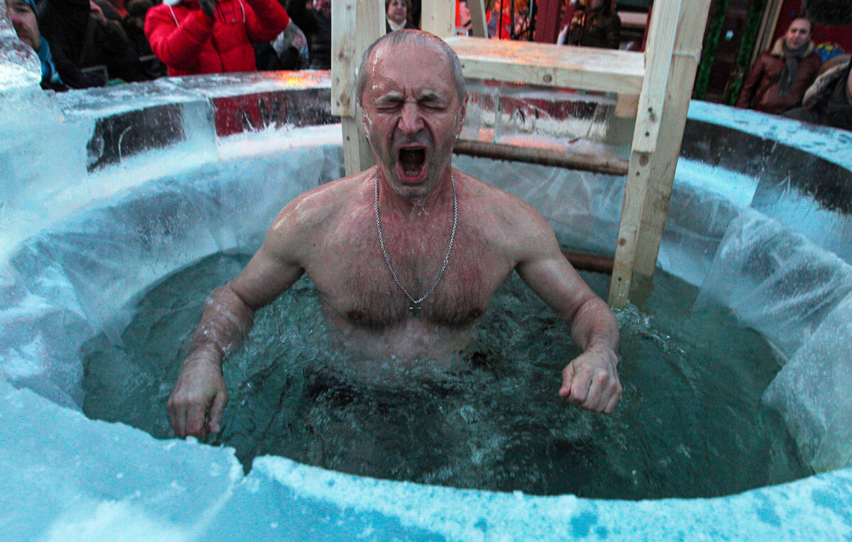 Ein Mann taucht in ein Eisloch während der Feierlichkeiten zum Dreikönigsfest der russisch-orthodoxen Kirche.
