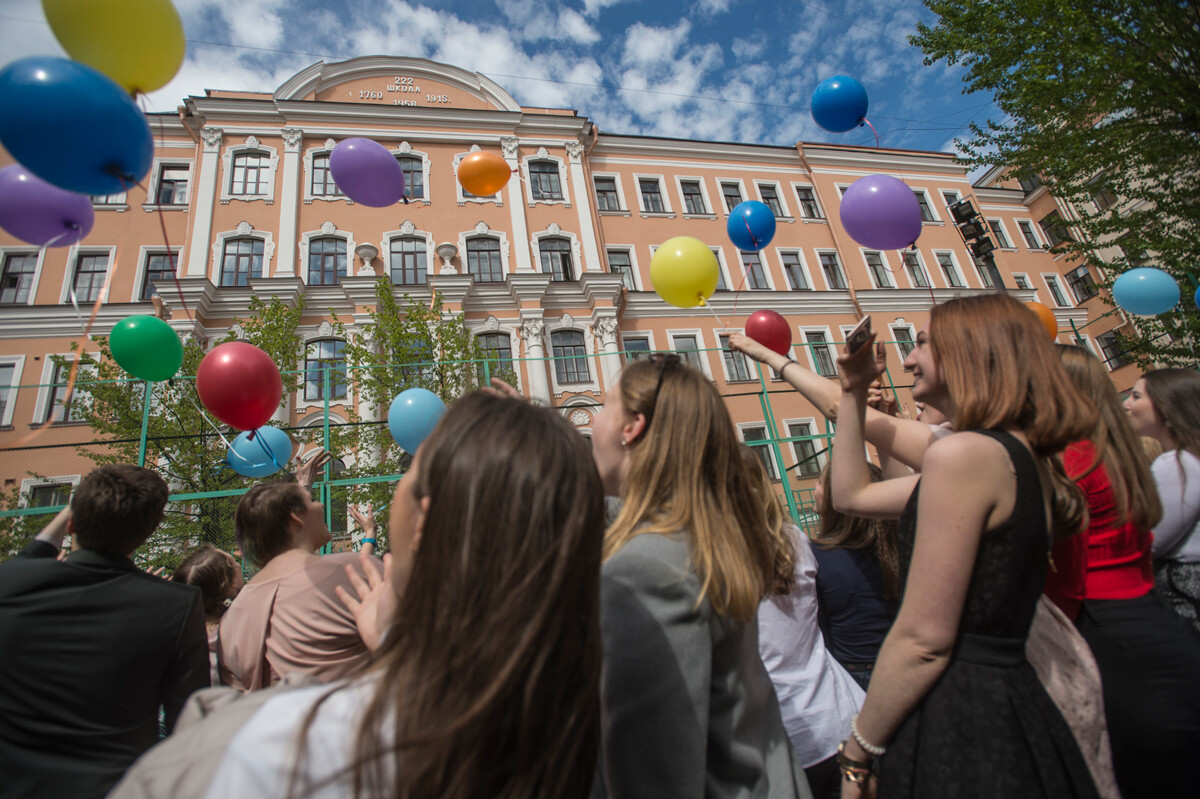 Absolventen lassen während der Abschlussfeier der Petrishule High School Nr. 222 in St. Petersburg, Russland, Luftballons steigen.