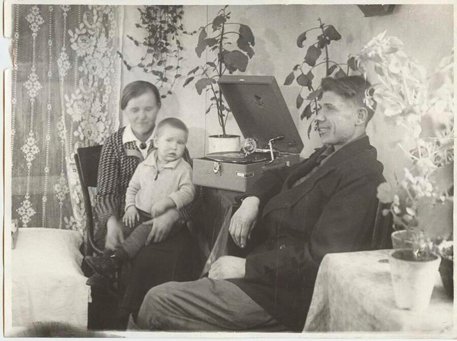 L'ouvrier stakhanovsite de Magnitogorsk V. Bardakov et sa famille écoutent un gramophone dans leur appartement, 1936.