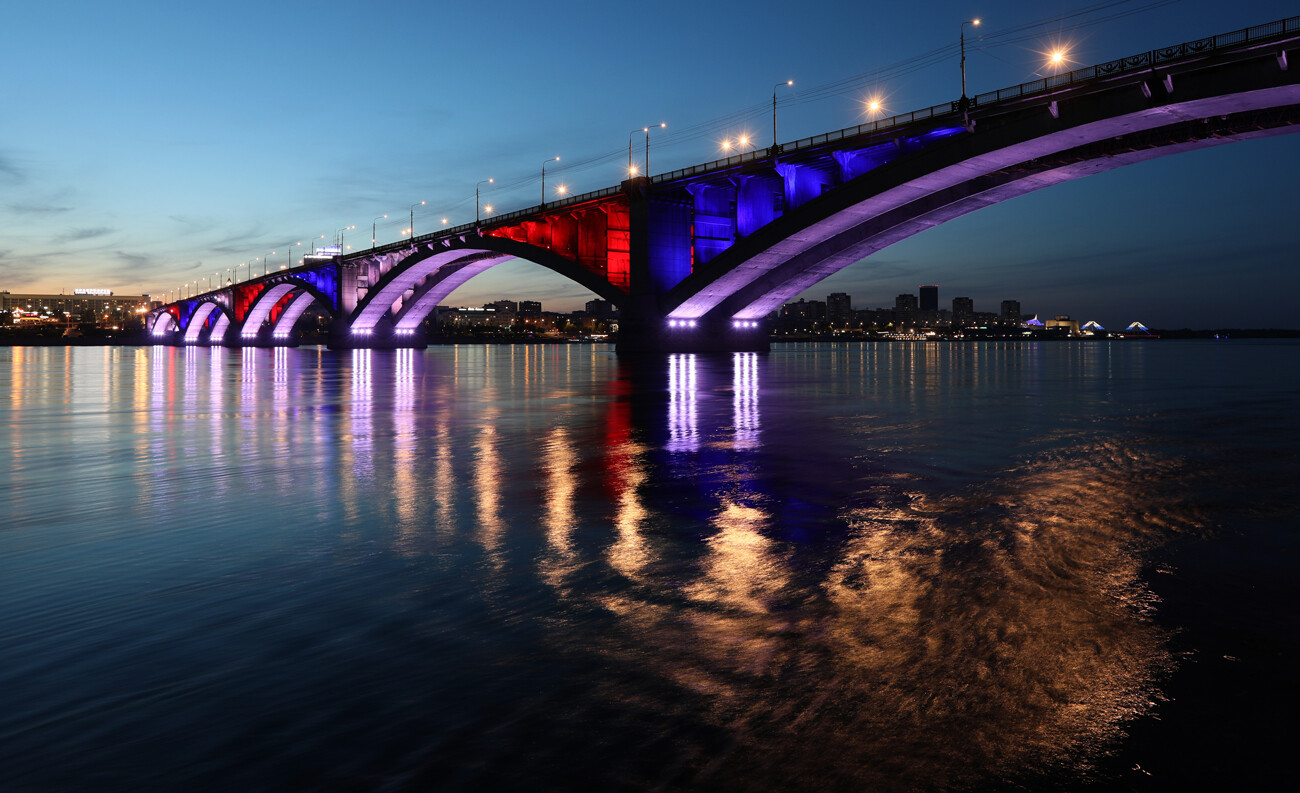 Le pont sur le fleuve Ienisseï dans la ville sibérienne de Krasnoïarsk (4 175 km de Moscou) illuminé aux couleurs du drapeau russe
