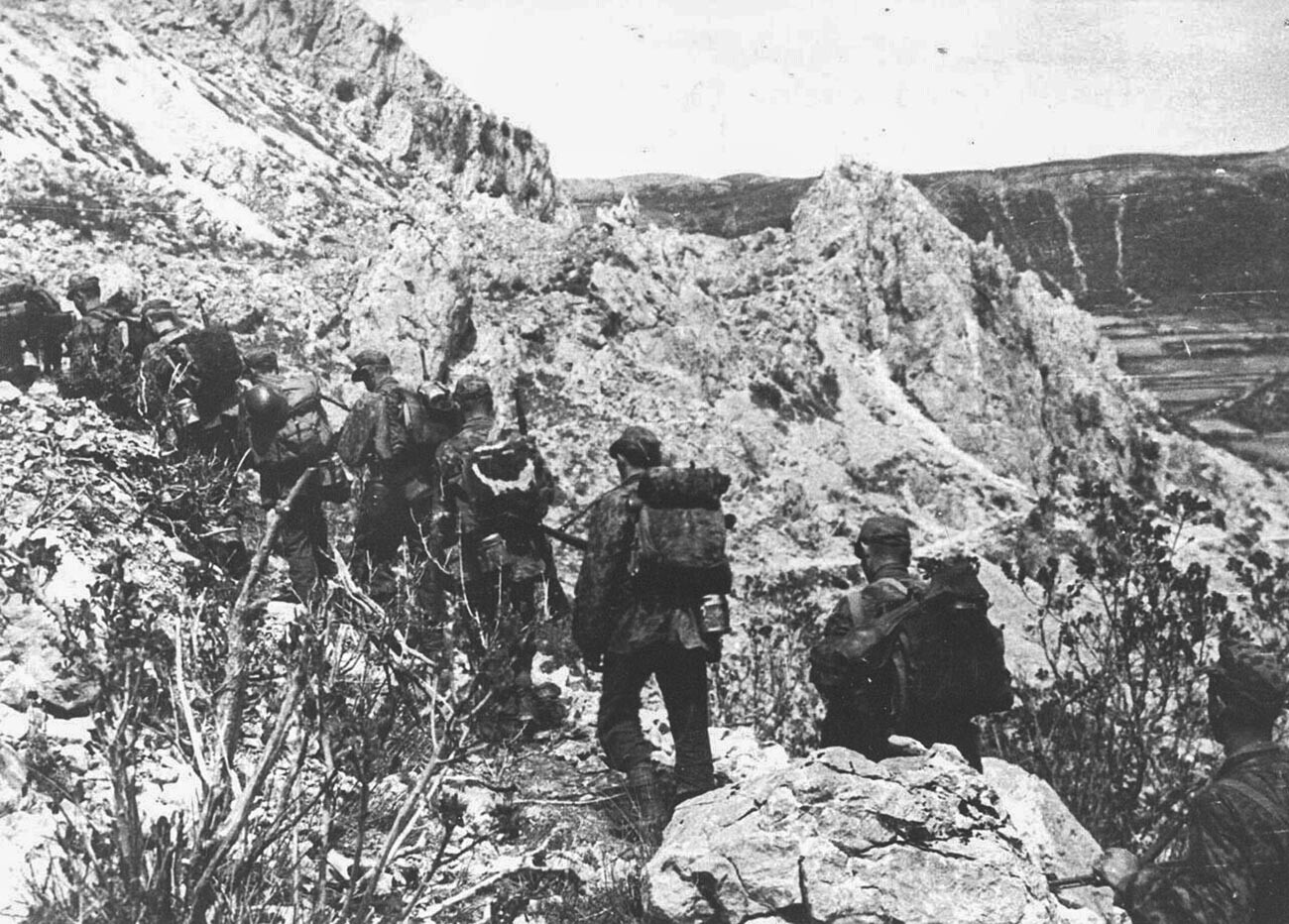 Припадници на 105 СС одред обучени за планинско војување настапуваат од Грахово кон Дрвар на 25 мај 1944.


