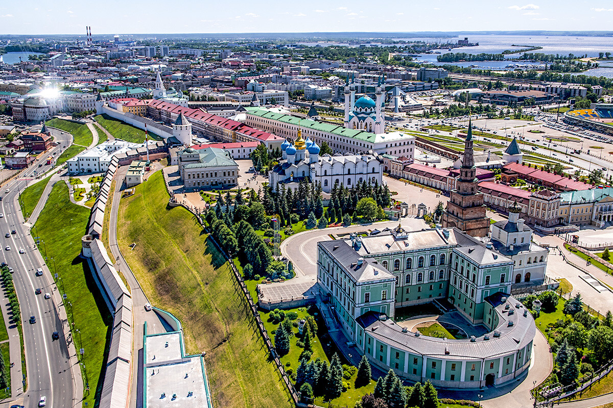 Imagem aérea do Kremlin de Kazan a partir de um helicóptero sobrevoando as muralhas, com a Catedral da Anunciação, a Torre Söyembikä e a Mesquita Kul Sharif pontuando o cenário