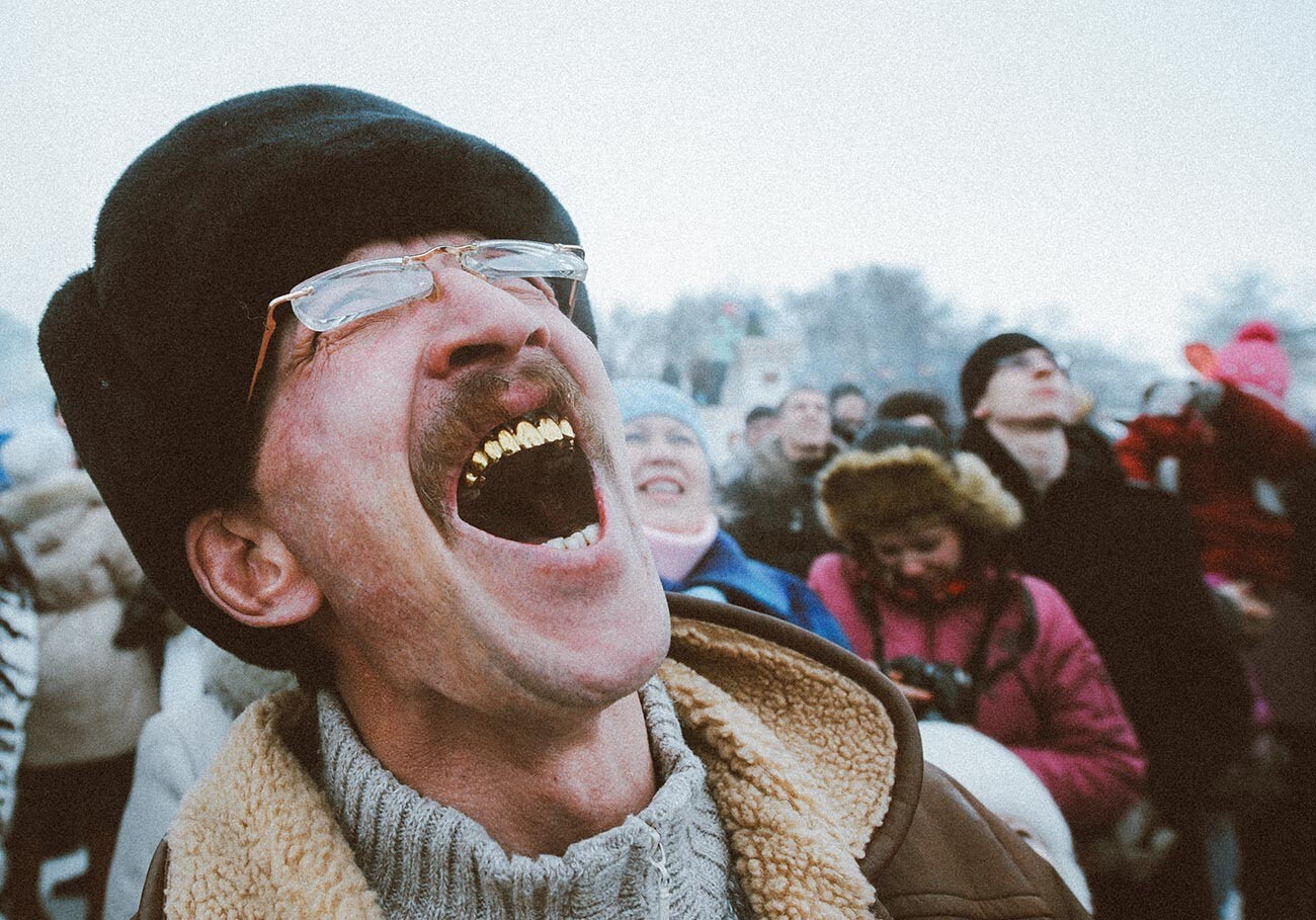 Moški skrbi za tekmovalca, ki se poskuša povzpeti na lesen drog za nagrado (petelina) na ljudskem festivalu, posvečenem praznovanju Maslenice (pusta) v Suzdalu