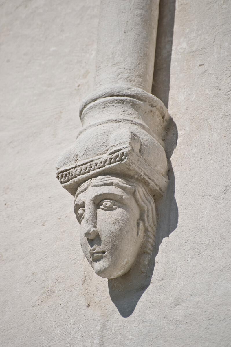  Iglesia de la Intercesión en el Nerl. Fachada oeste, columna del friso de la arcada sostenida por un bloque de consola con una cabeza femenina esculpida. 18 de julio de 2009.