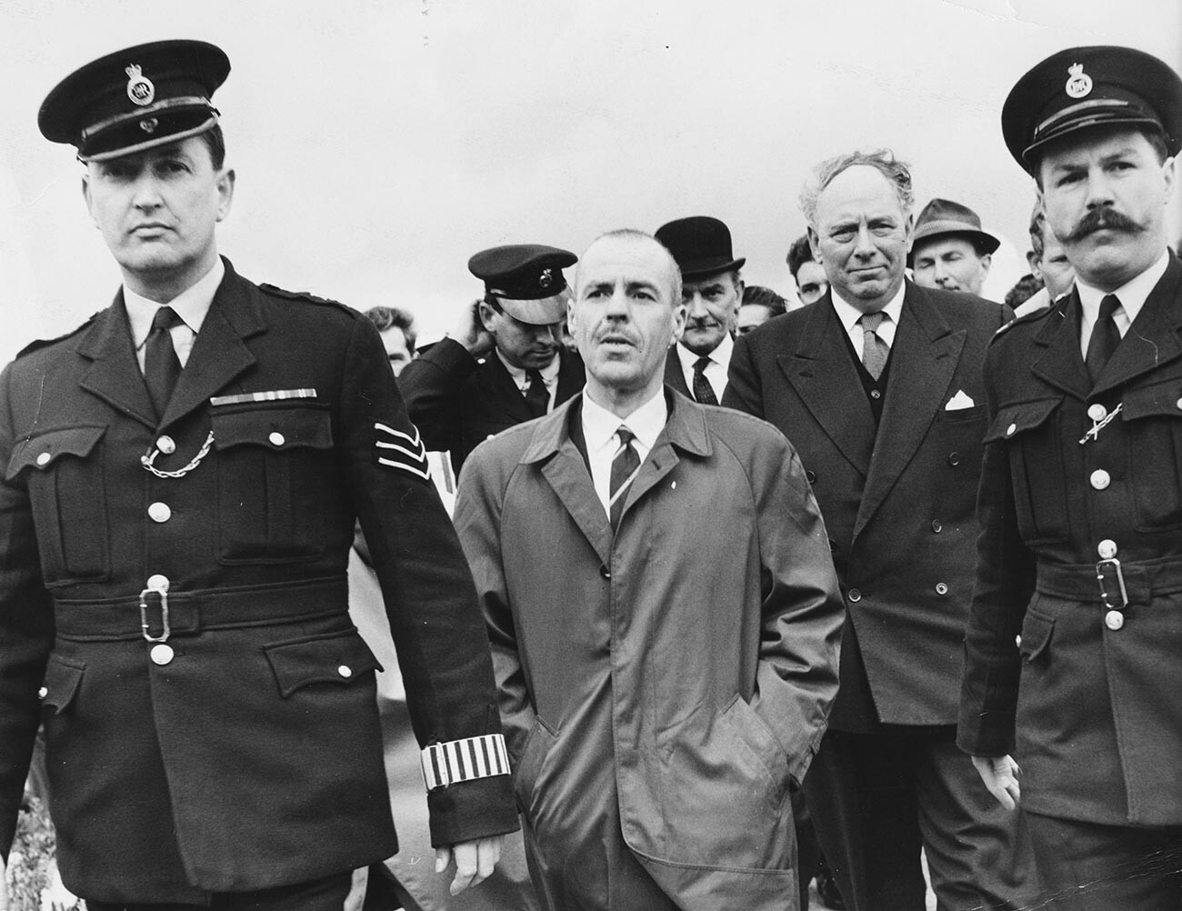 Greville Wynne being escorted by policeman after arriving back home from the Soviet Union, at Northolt Airport, England, April 22nd 1964.