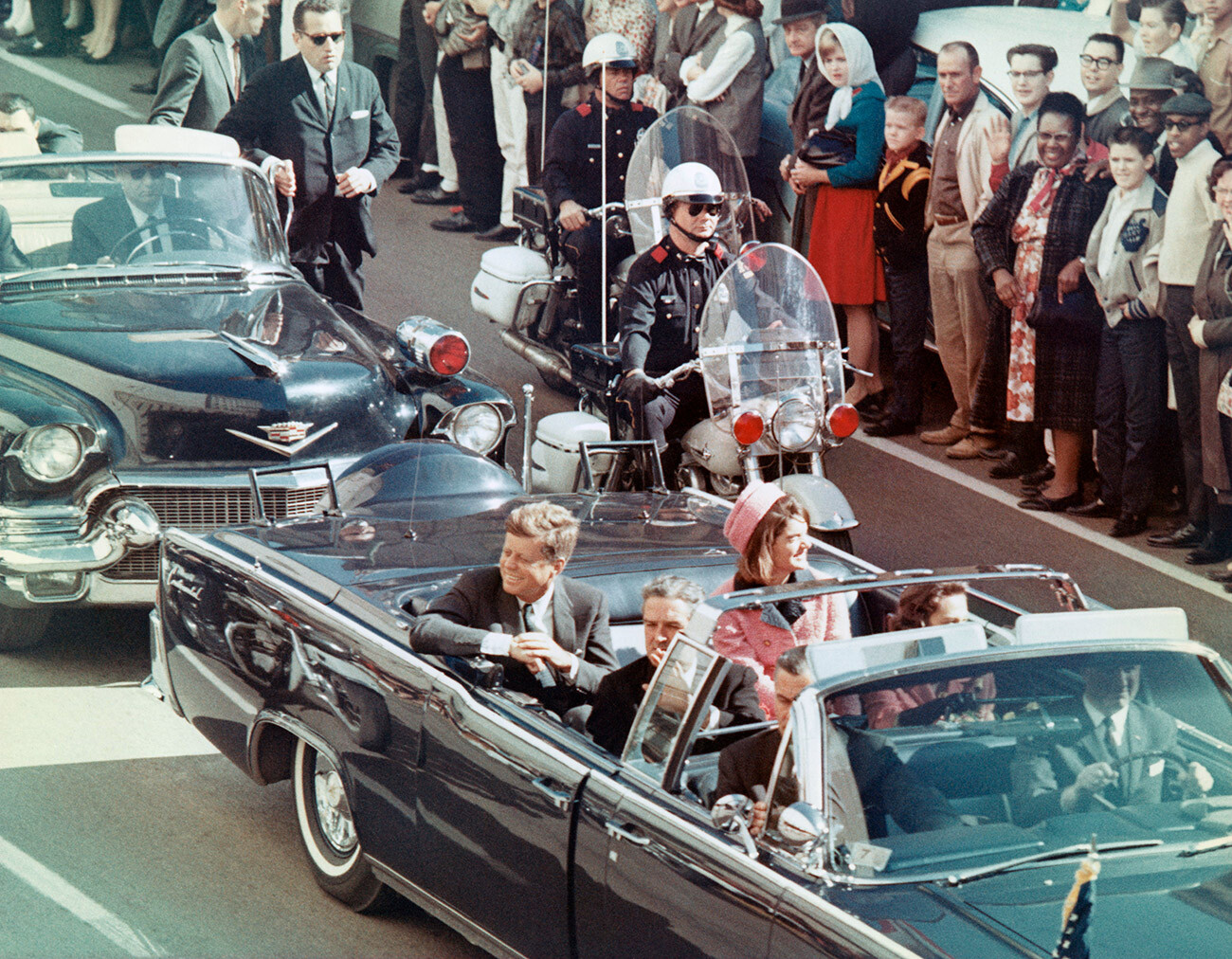 President and Mrs. John F. Kennedy smile at the crowds lining their motorcade route in Dallas, Texas, on November 22, 1963. Minutes later the President was assassinated as his car passed through Dealey Plaza.