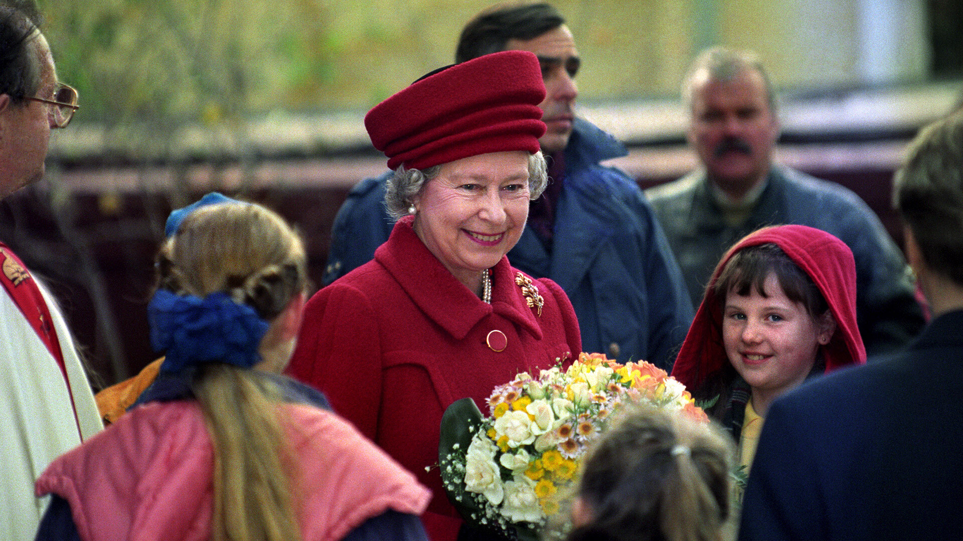 Nasmejana Kraljica Elizabeta II. nosi cvetje, ko zapušča cerkev svetega Andreja v Moskvi 