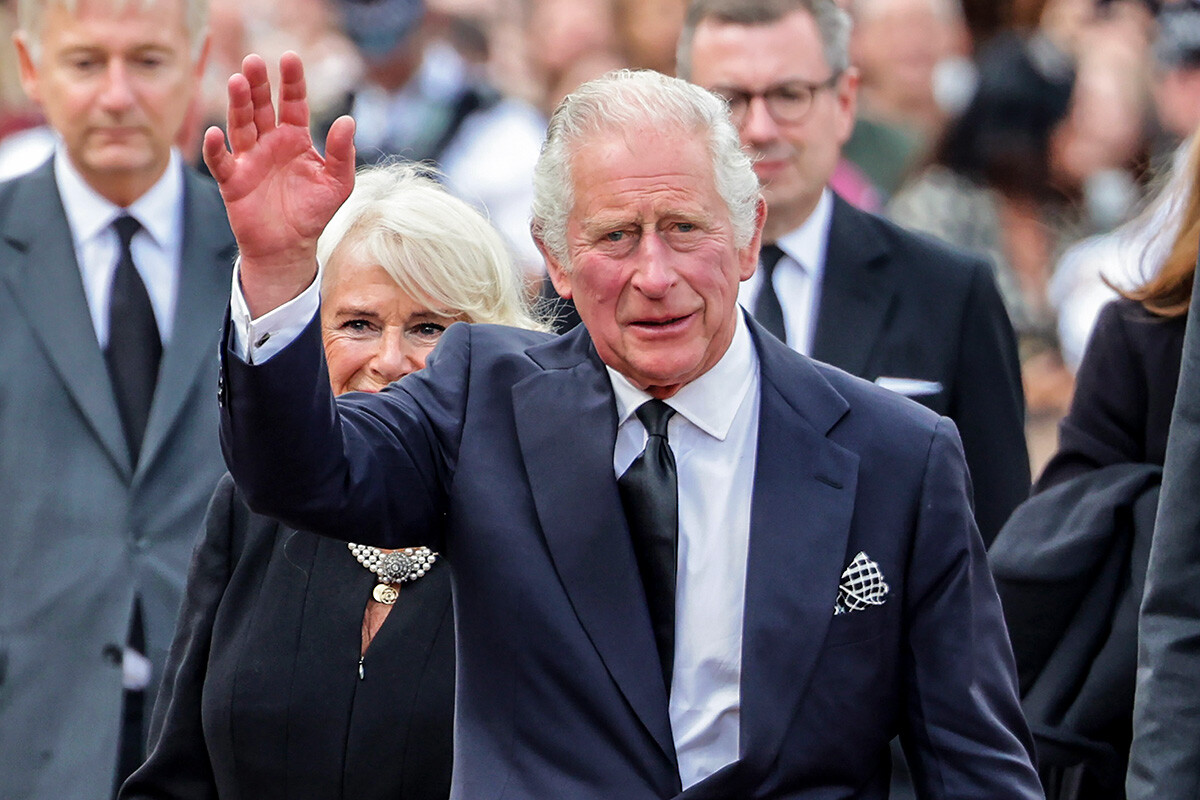 King Charles III waves to the public after viewing floral tributes to the late Queen Elizabeth II outside Buckingham Palace on September 09, 2022 in London, United Kingdom. 