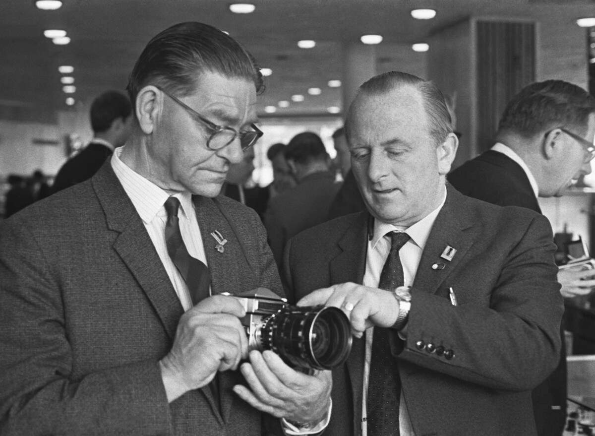 Победители конкурса, организованного в 1967 году советско-английской фирмой «Текникал энд оптикал эквипмент», британские бизнесмены Б. Н. Маршалл и Ф. Фокс (слева направо), реализовавшие наибольшее количество кинофотоаппаратуры с маркой «Сделано в СССР», во время осмотра фотоаппарата «Зенит-6».