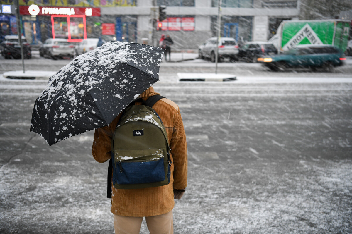 Moški z dežnikom med prvim sneženjem v Novosibirsku. 