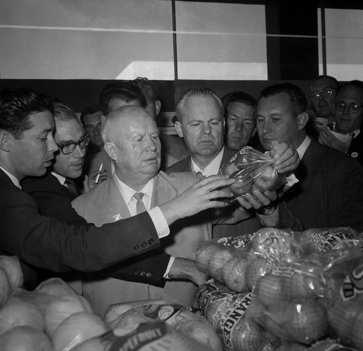 Съветският премиер Хрушчов вдига целофанова торбичка, пълна с ябълки в супермаркет и пита за цената от продавач в Сан Франциско на 21 септември 1959 г.