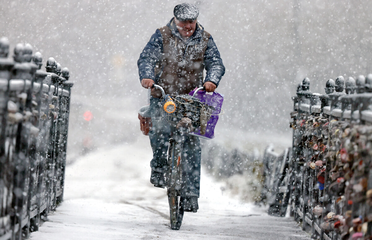 Región de Ivánovo. Kineshma. Un hombre en bicicleta durante una nevada. 