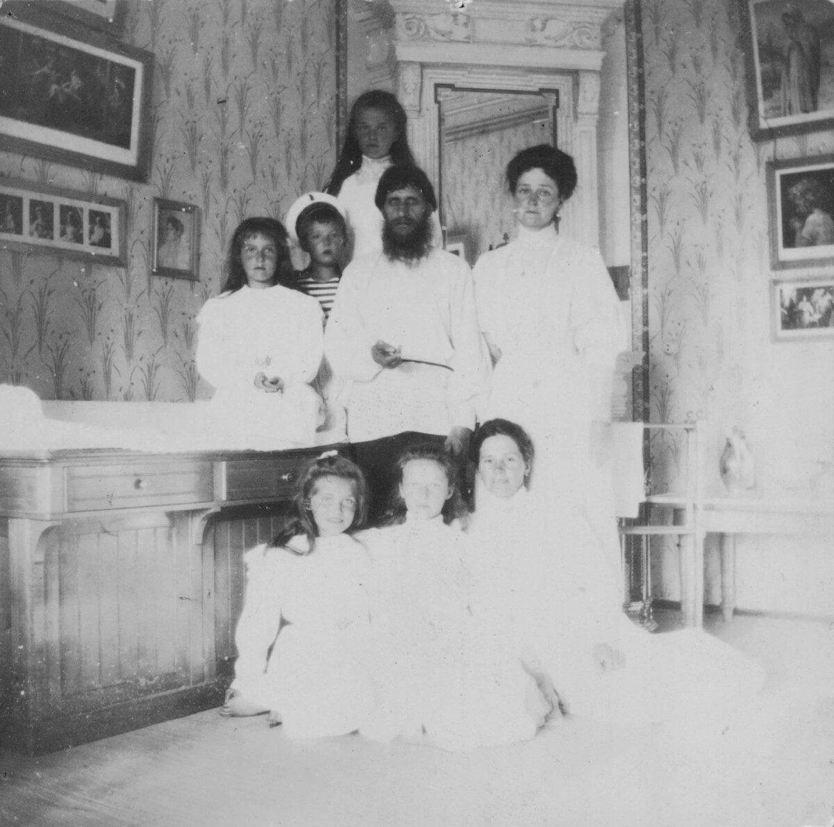 Kaiserin Alexandra Fjodorowna mit ihren Kindern, Rasputin und der Gouvernante Maria Wischnjakowa.