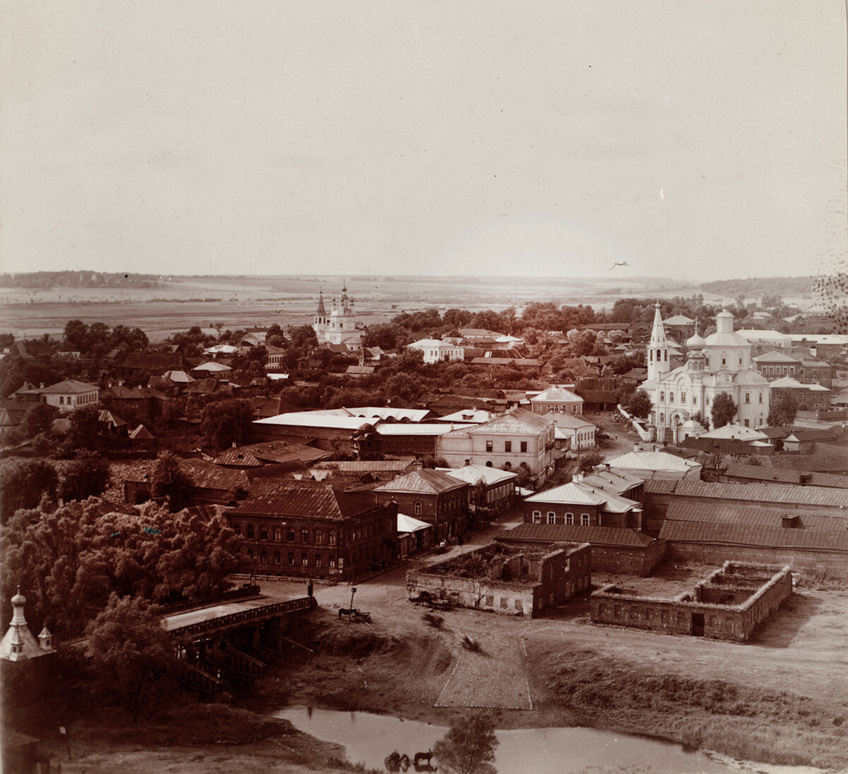 Vue sur Viazma depuis le clocher de la cathédrale de la Trinité, en direction du domaine de Khmelita. Les églises de l’Annonciation (à gauche) et de l’Entrée-de-Christ-à-Jérusalem (à droite) ont été démolies sous l’ère soviétique. Photo prise à l’été 1912