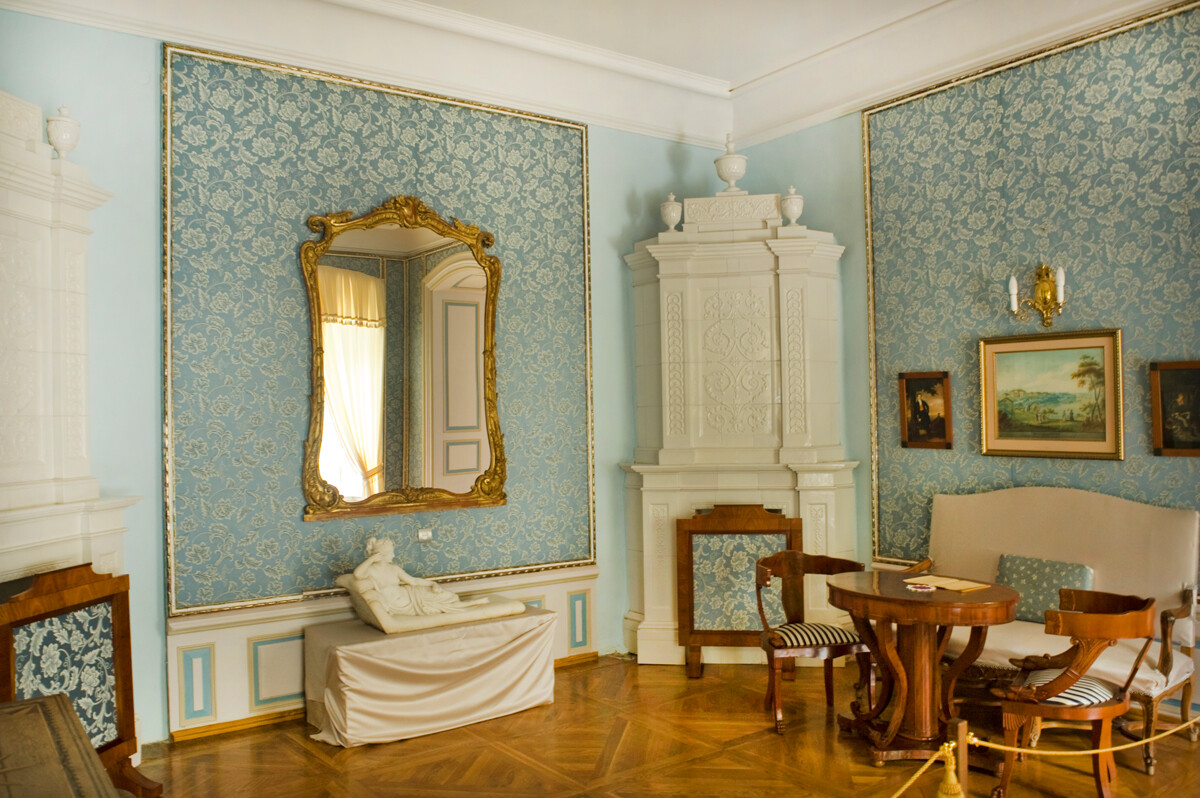 Manoir, salon bleu avec poêle en céramique blanche de style néoclassique