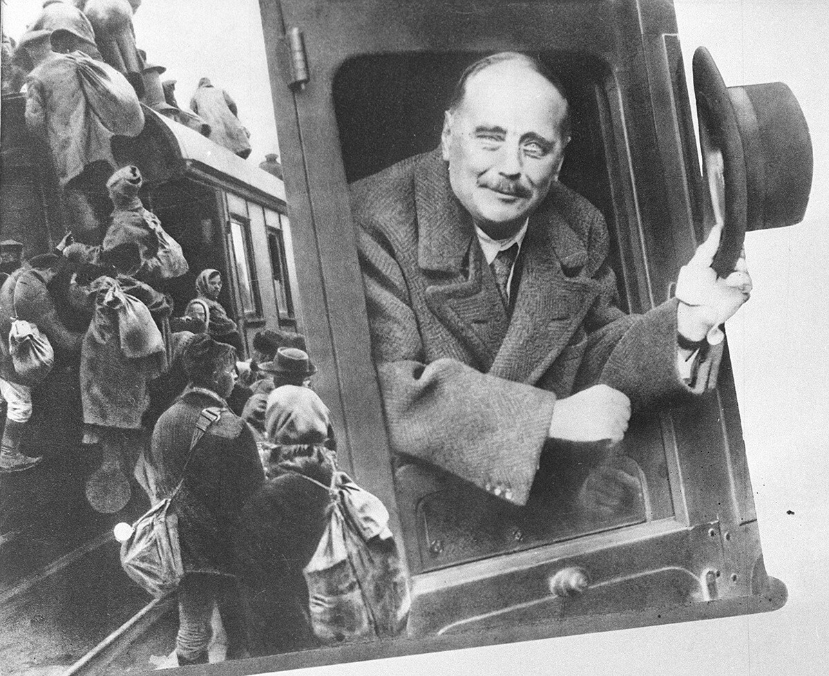 Angleški pisatelj Herbert Wells gleda skozi okno vagona. Reprodukcija fotografije.