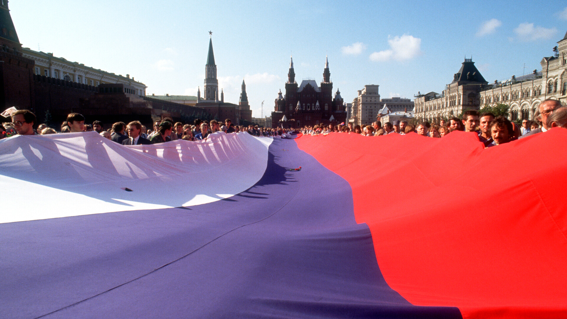 Demonstranti po neuspelem puču leta 1991 na Rdečem trgu izobesijo velikansko rusko zastavo. 18. avgusta 1991 so sovjetski privrženci trde linije poskušali spodnesti voditelja M. Gorbačova in predsednika B. Jelcina, vendar je puč s pomočjo množičnih javnih demonstracij le nekaj dni pozneje propadel.