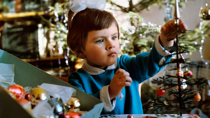 Una bambina decora un albero di Natale, 1973