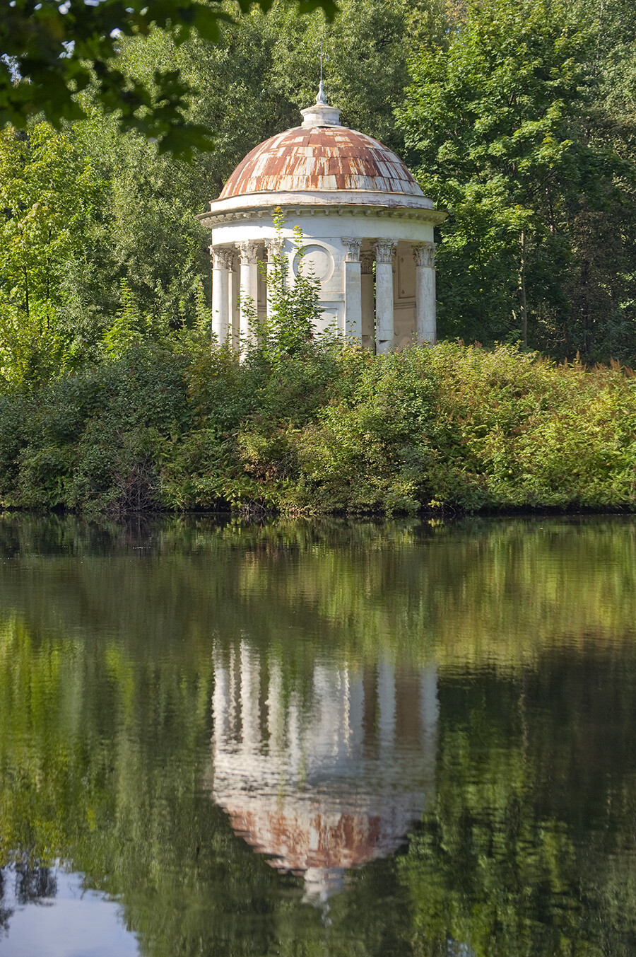 Bykovo estate park. Neoclassical rotunda reflected in pond. August 30, 2014.
