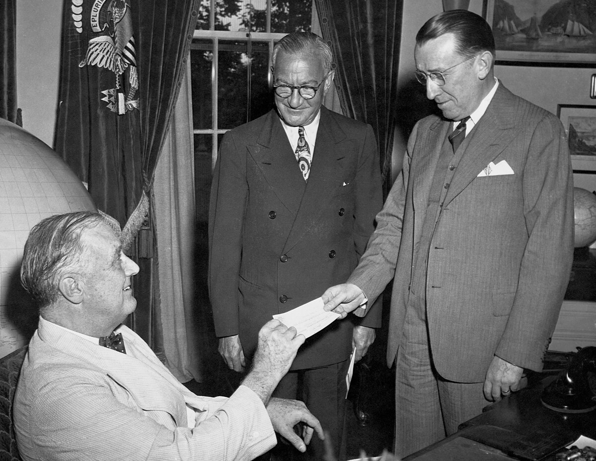 El presidente Roosevelt recibe un cheque de un millón de dólares de Basil O'Connor y Nicholas M. Schenck, 1933