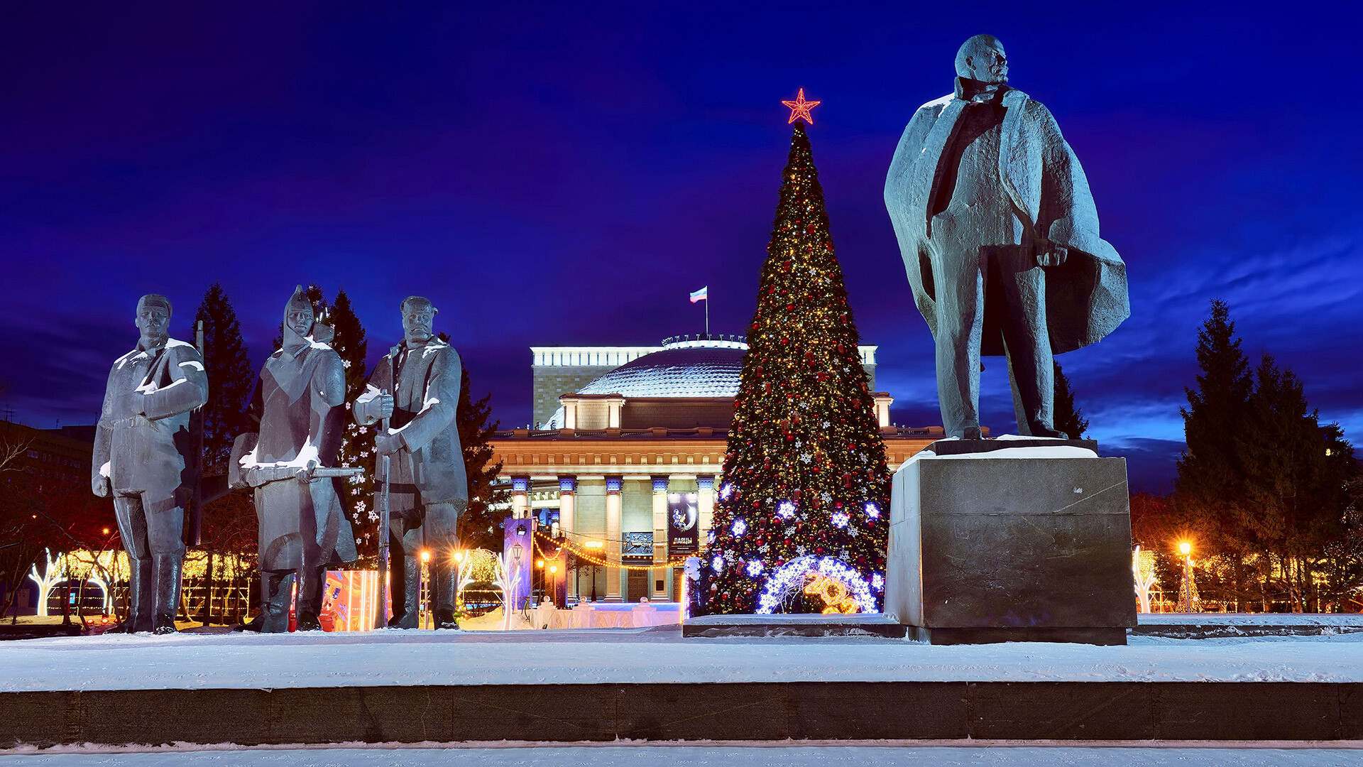Novosibirsk, Sibirija, Rusija, 16.01.2022. Leninov trg v zimski noči. Kipi Lenina, delavca, vojaka in kmeta v ozadju.