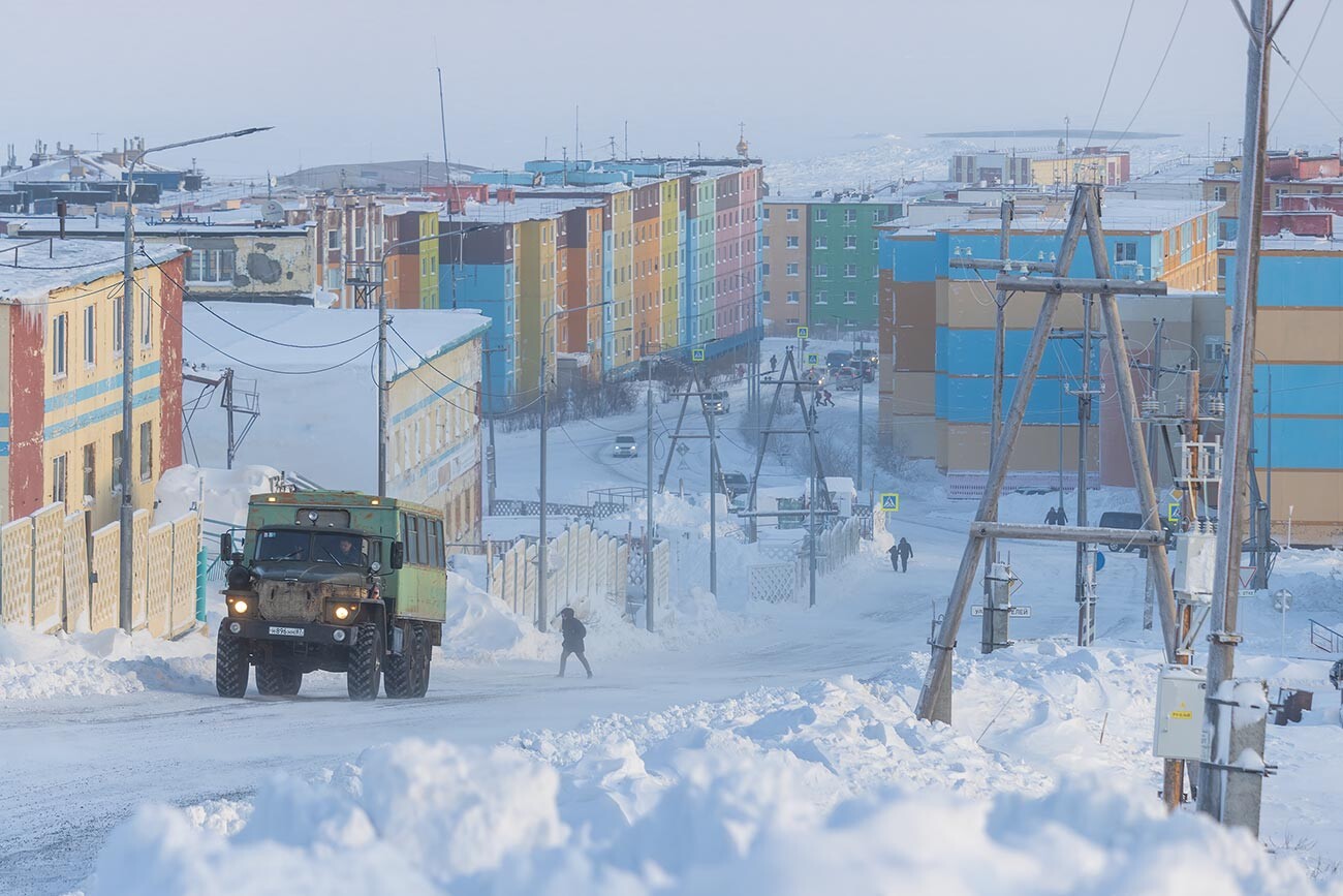Pogled na zasneženo ulico severnega arktičnega mesta. Hladno mrzlo zimsko vreme v Sibiriji na skrajnem severu Rusije. Ljudje in avtomobili zunaj. 21. januar 2020. Anadir (Čukotka, Rusija) 
