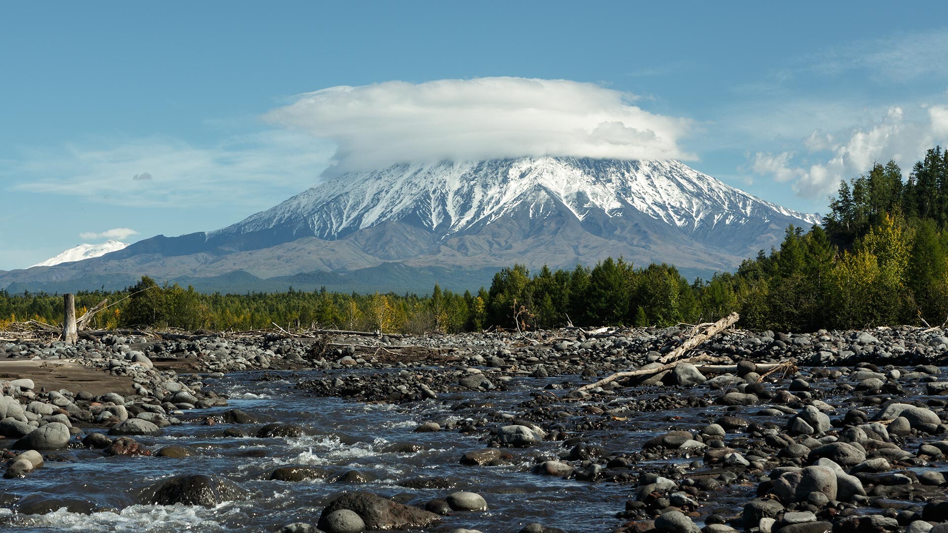 Pogled na vulkan Ostri Tolbačik iz struge reke Studjonaja na Kamčatki. 
