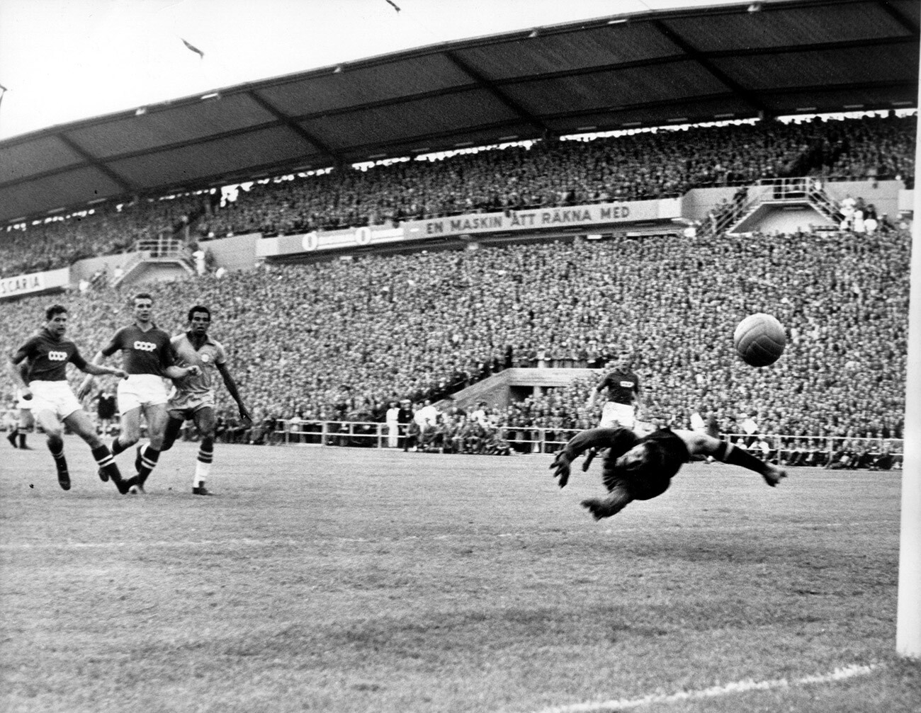 Brazilian striker Vava kicks past two opponents and scores the 1:0 lead goal during the 1958 FIFA World Cup group match against the USSR.