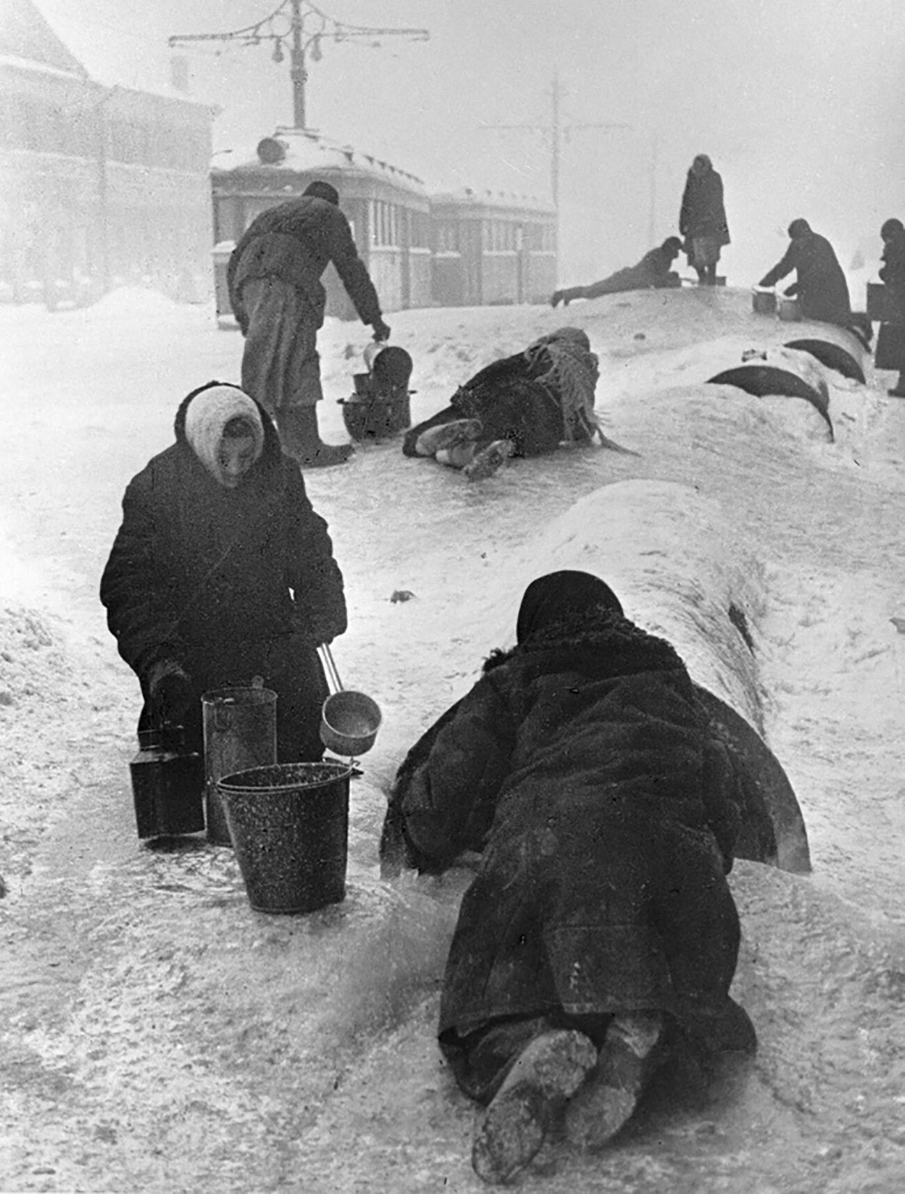 Einwohner von Leningrad schöpfen Wasser aus einer gebrochenen Wasserleitung auf einer vereisten Straße.
