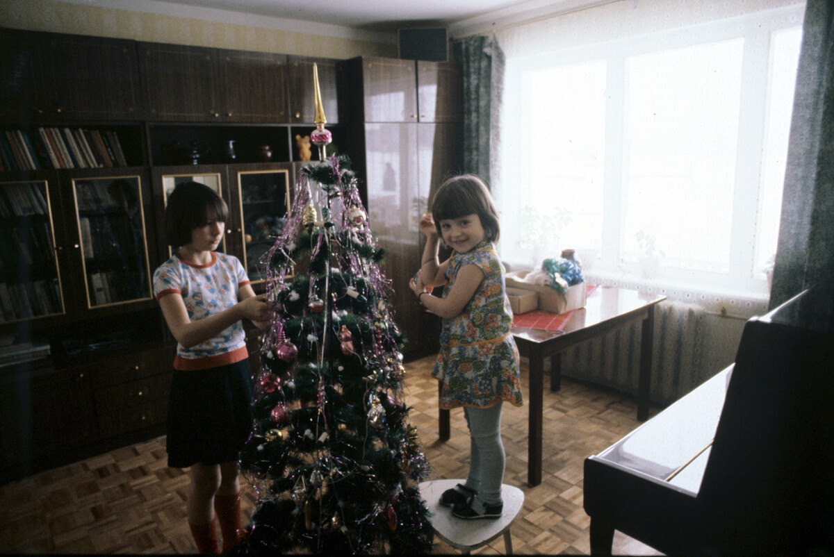 Otroci okrasijo božično drevo - jelko. Naselje Veljaminovo, 1983 