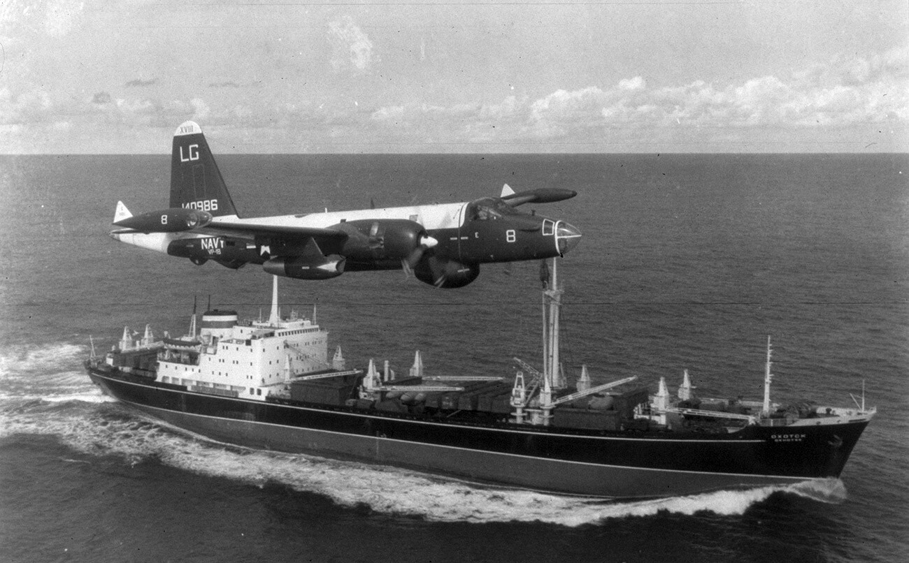 A P2V Neptune U.S. patrol plane flies over a Soviet freighter during the Cuban missile crisis in this 1962 photograph.