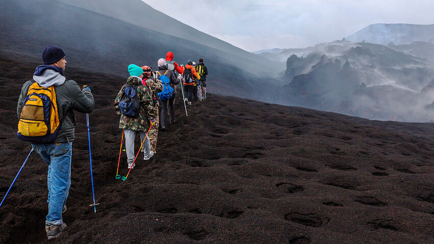 Туристи ходят към изригващ вулкан 