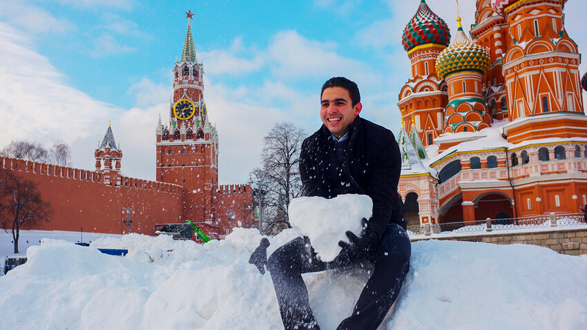 A foreign tourist poses in front of St. Basil's Cathedral in Moscow.