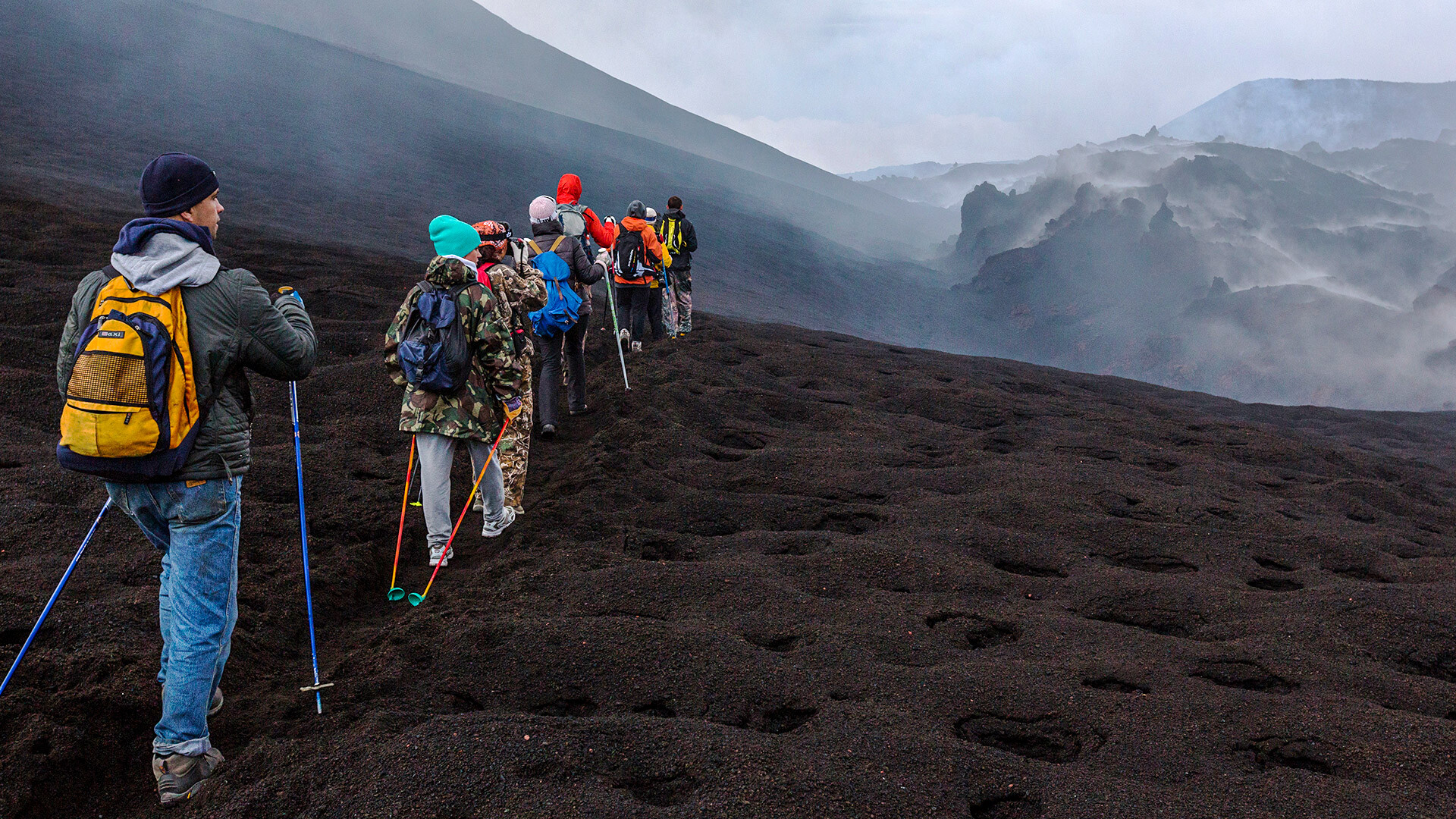 Sejumlah wisatawan berjalan di area letusan Gunung Berapi Tolbachik.