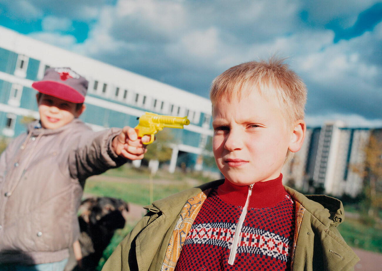 Deček drži igračo pištolo ob glavi svojega prijatelja, Sankt Peterburg