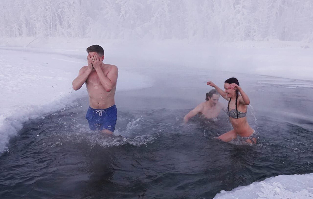 Orang-orang berenang di mata air panas Oymyakon.