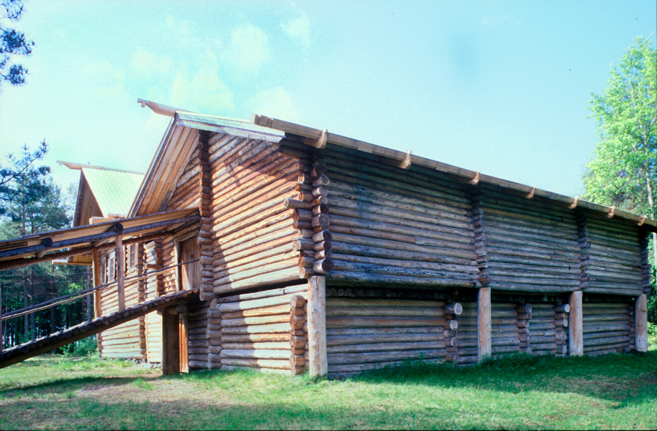 Malye Korely. Kirillov house, originally built in Kiselyovo village, Kargopol District. Back view with ramp to barn attached along side the main house. Farm animals kept on ground level of barn. Large posts ensured stability when rotted logs on ground level needed to be replaced. June 21, 2003