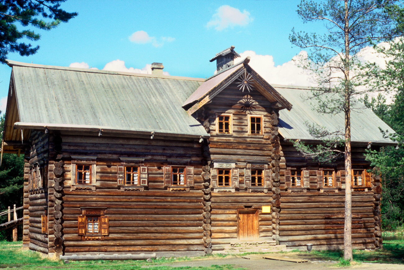 Malye Korely. Pukhov house, originally built in Bolshoi Khalui village, Kargopol District. Low door opens to corridor between two log walls. The ground level contained winter quarters & larder. The upper level was used in warmer months. Ramp to attached barn visible at back on left. June 9, 1998