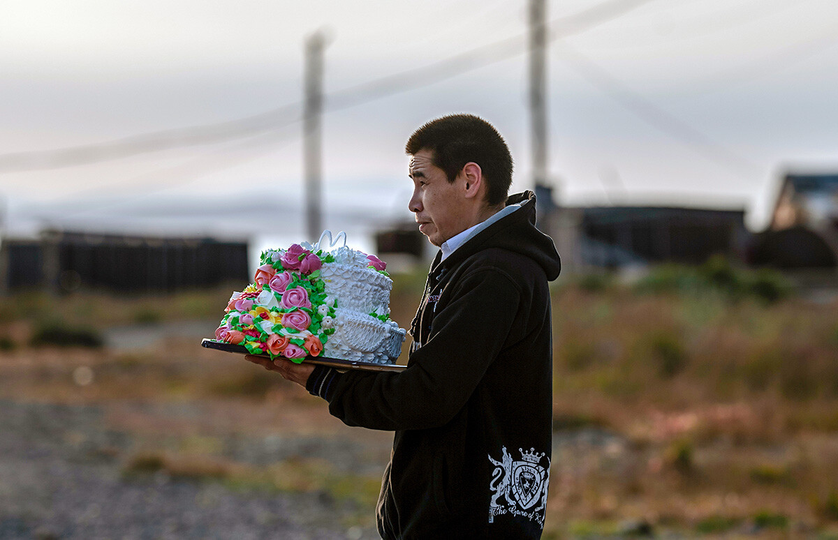 Un invitado de la boda con una tarta en la calle del pueblo de Lórino, en Chukotka. 
