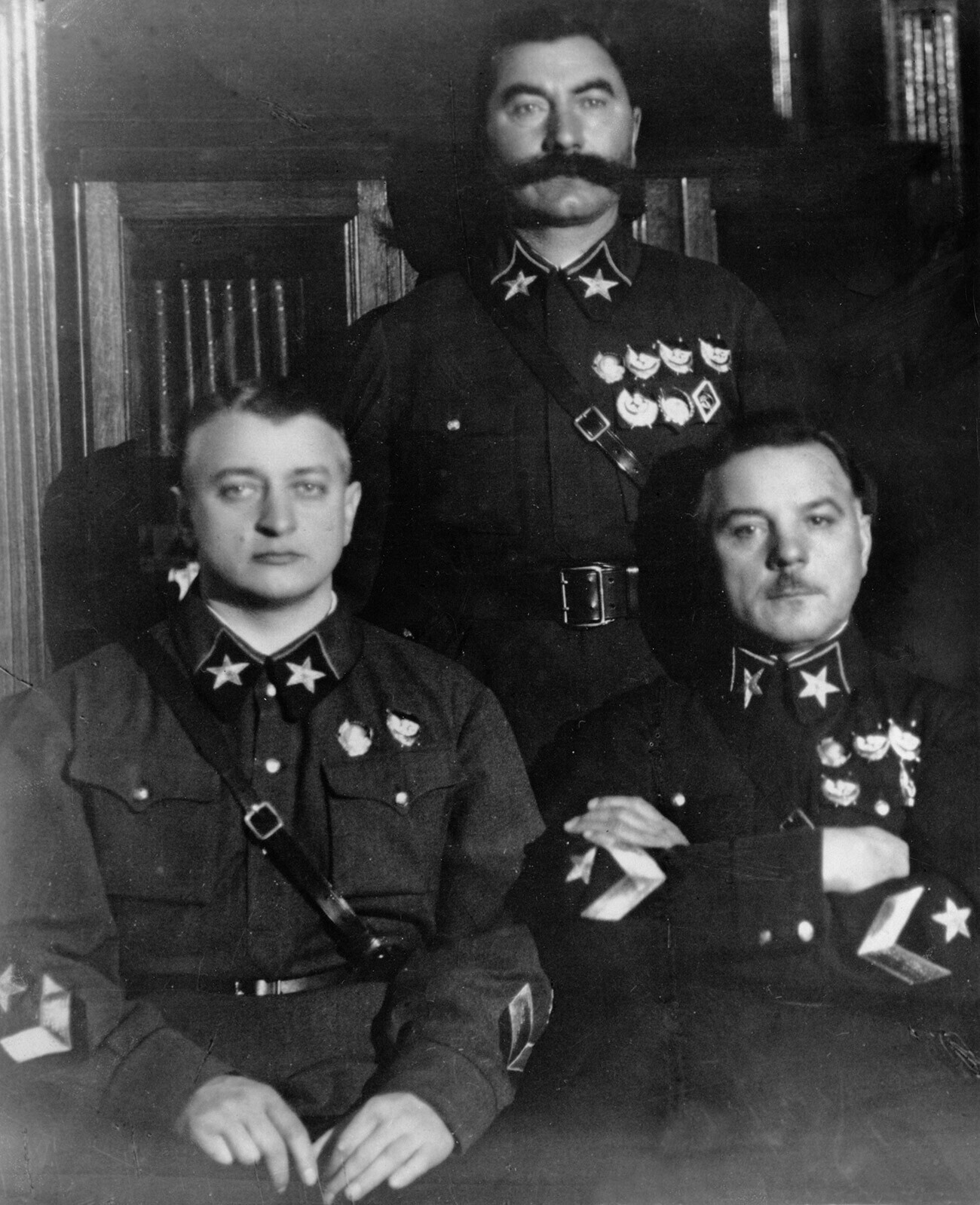 Советските војсководци, седат: десно маршал К. Ворошилов, маршал М. Тухачевски, стои: маршал С. Буѓони, СССР, 1935 година.
