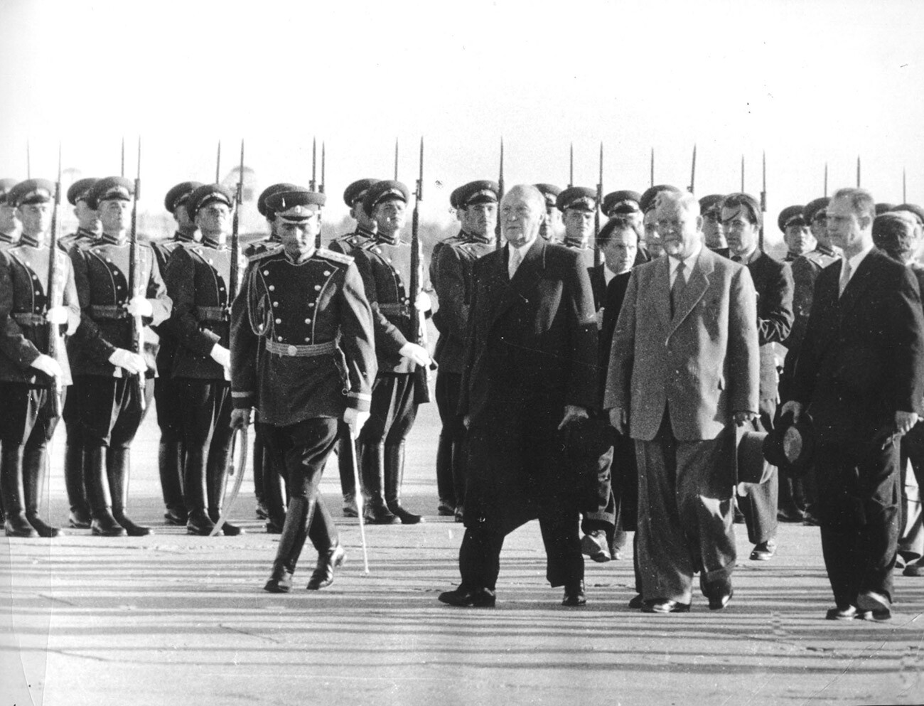 Bundeskanzler Konrad Adenauer (Mitte) schreitet nach seiner Ankunft in Moskau am 8. September 1955 die Front einer Ehrenkompanie ab. Rechts der sowjetische Ministerpraesident Nikolai Bulganin. 