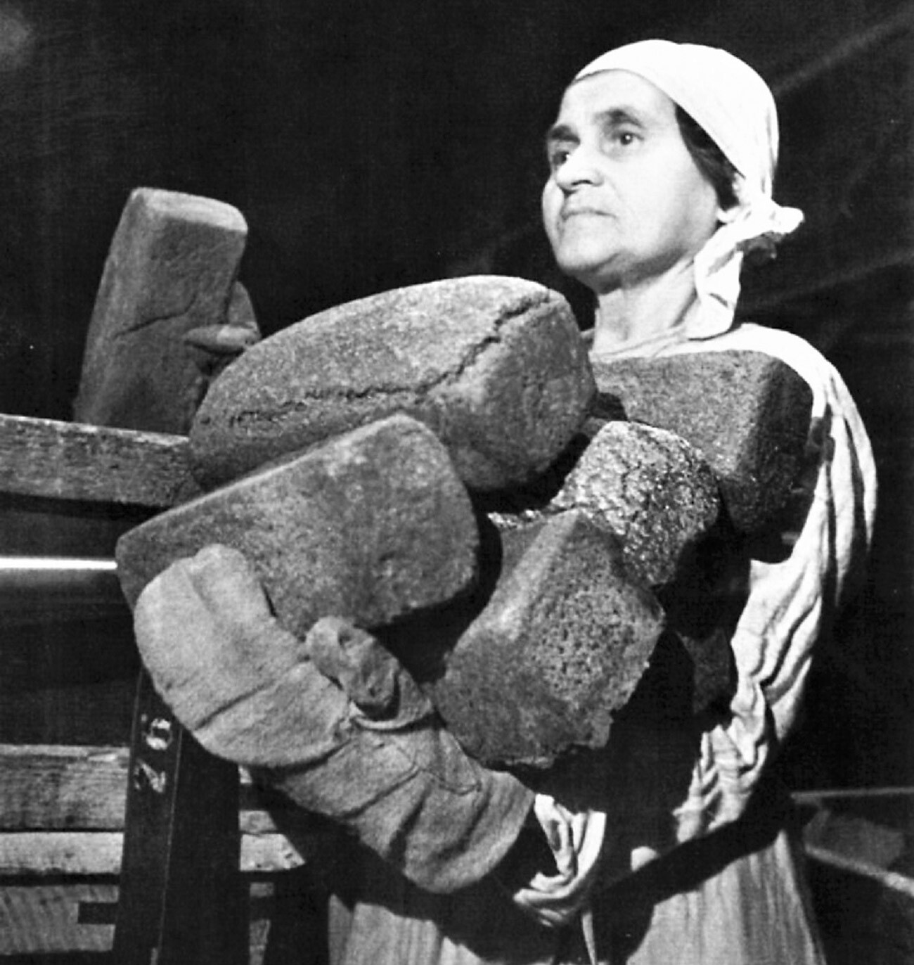Emilija Čibor, delavka pekarne št. 61, imenovane po A. E. Badajevu, zlaga kruh v škatle za pošiljanje v trgovino v obleganem Leningradu. 